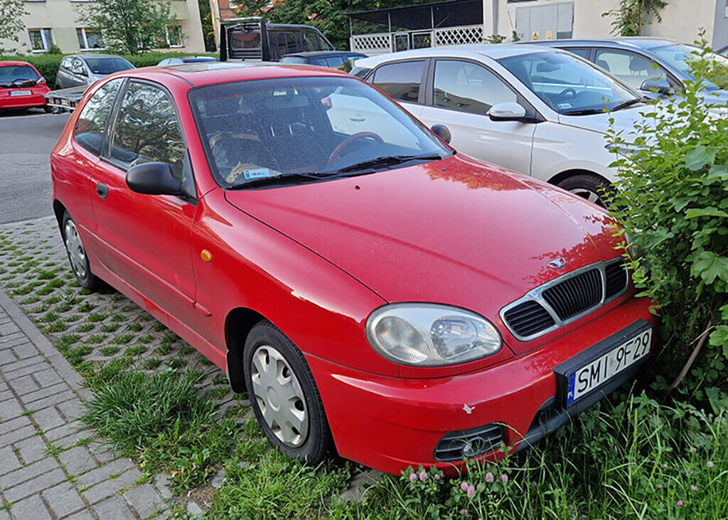 Czerwony Daewoo Lanos Sport na parkingu